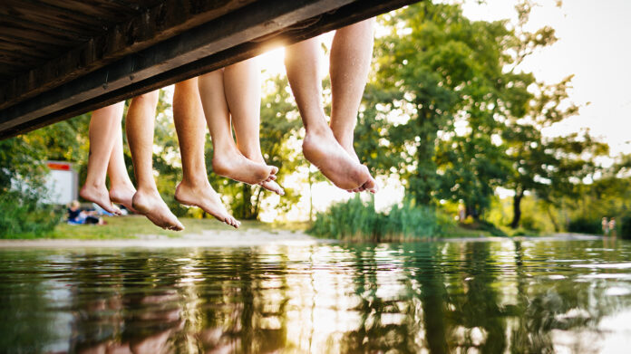 four young people sitting on a jetty