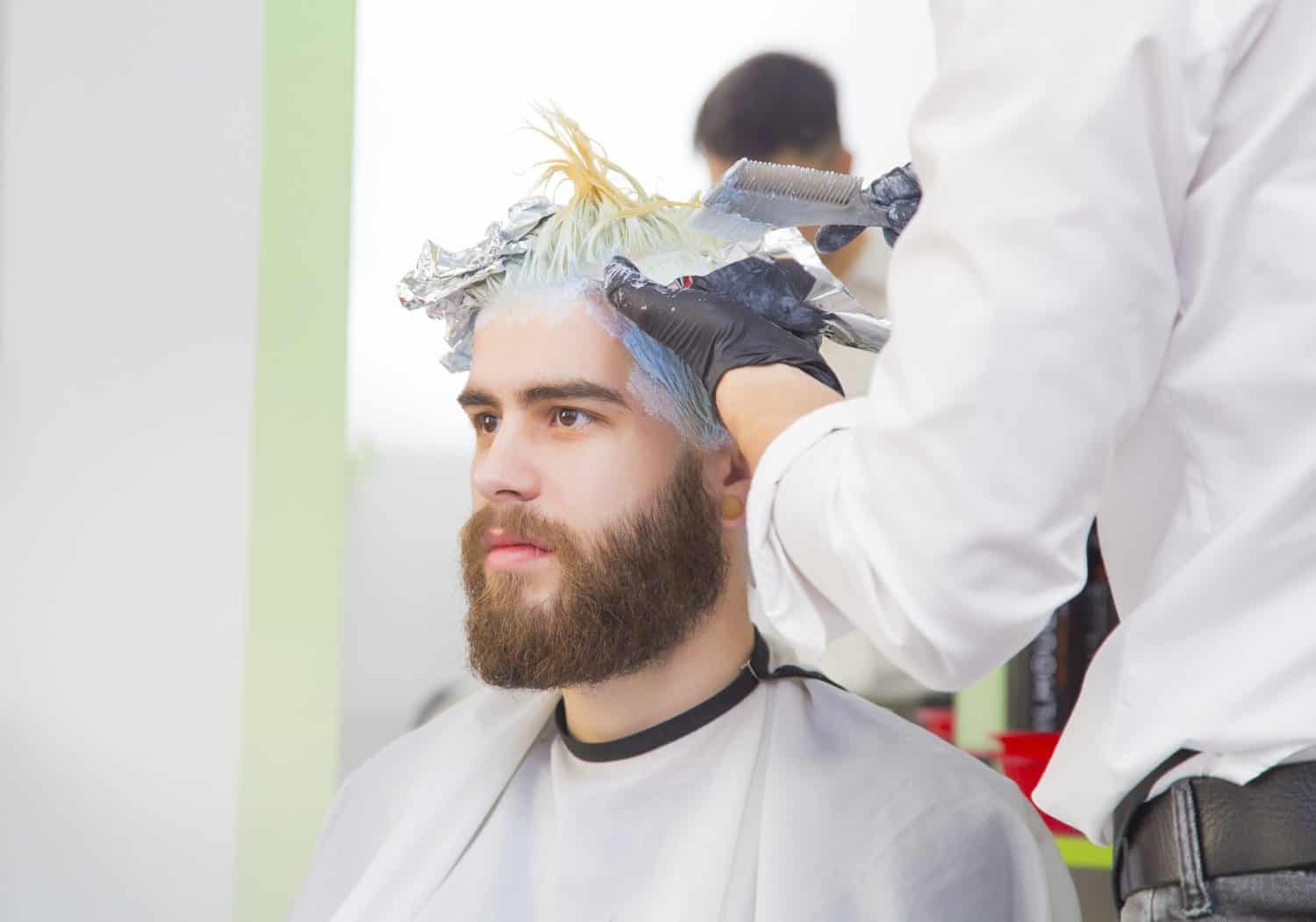 Process of a guy having his hair dyed at hairdresser.