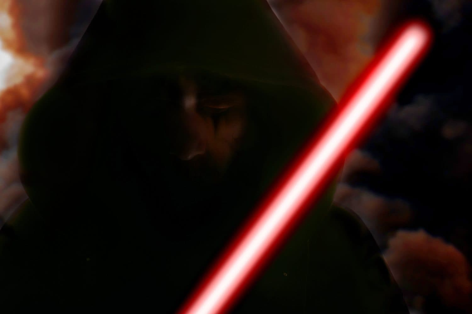 Hooded man in shadow with light sword on burning background.