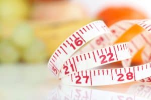 Weight watcher - Measuring tape with different fruits at the background (V-Format ID 174374312)