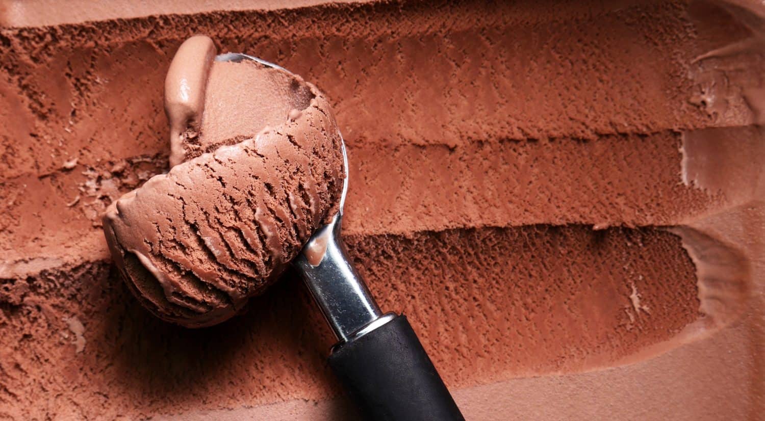 Top view Close up Stainless steel ice cream scoop is scooping chocolate flavor ice cream meat.