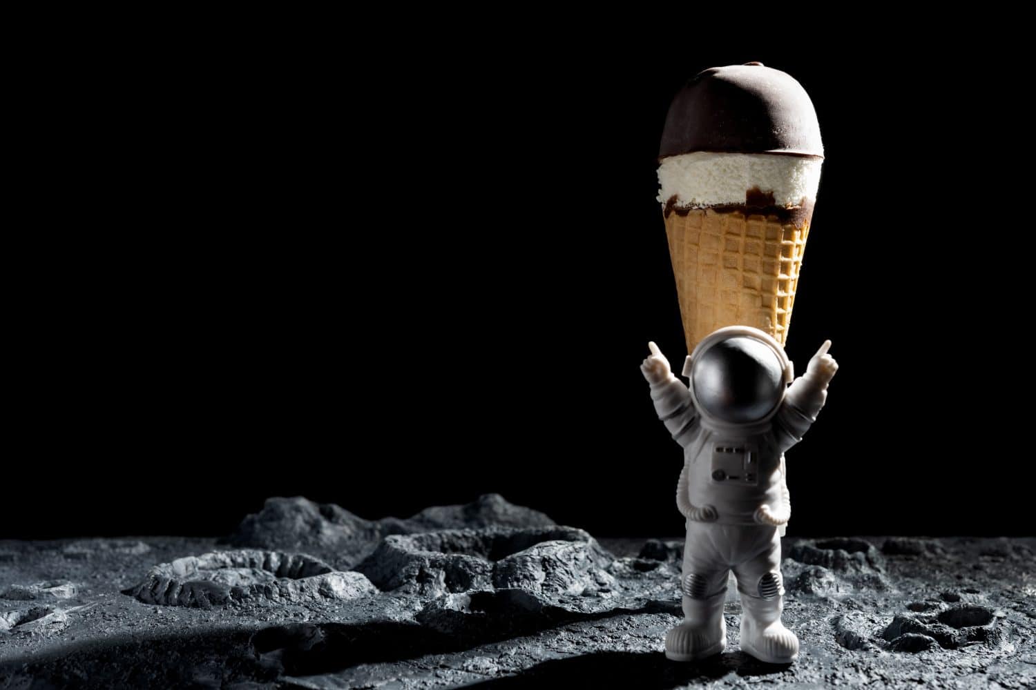 astronaut with a chocolate ice cream cone on a rough surface with craters