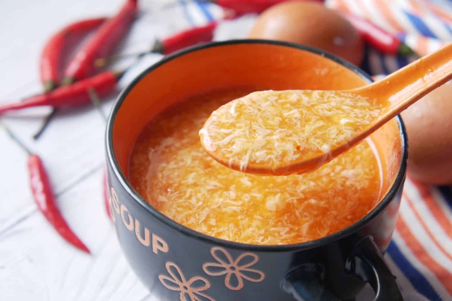 Traditional chinese egg drop soup with chili and egg on table,