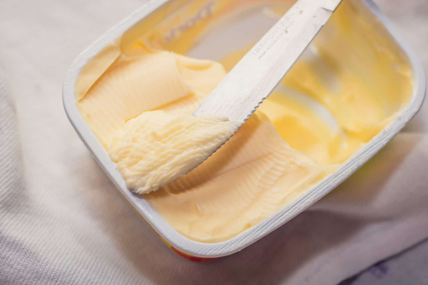 taking margarine from the jar with the knife