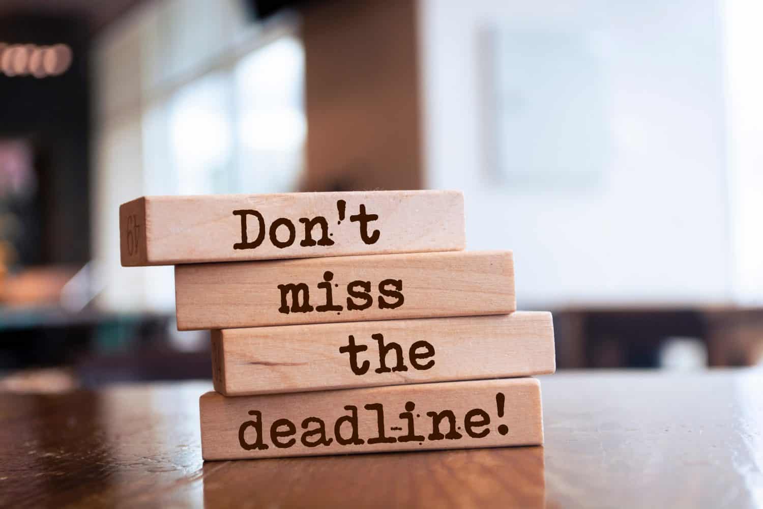 Wooden blocks with words 'Don't miss the deadline'.