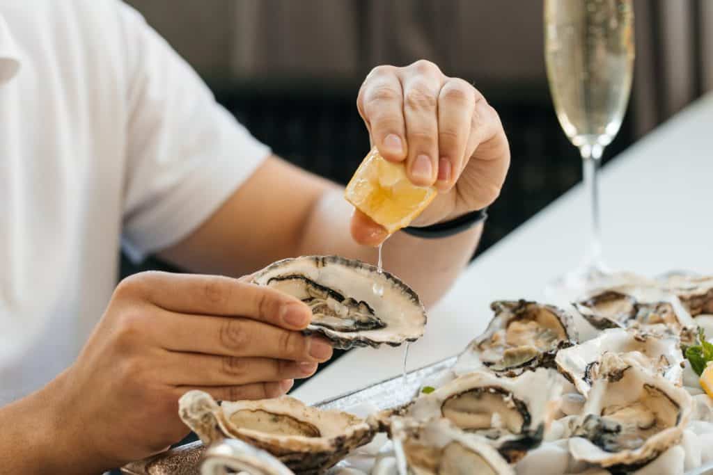 oyster. Man eating shellfish. Seafood and Mediterranean cuisine with mussels in shell. oyster in luxury restaurant.