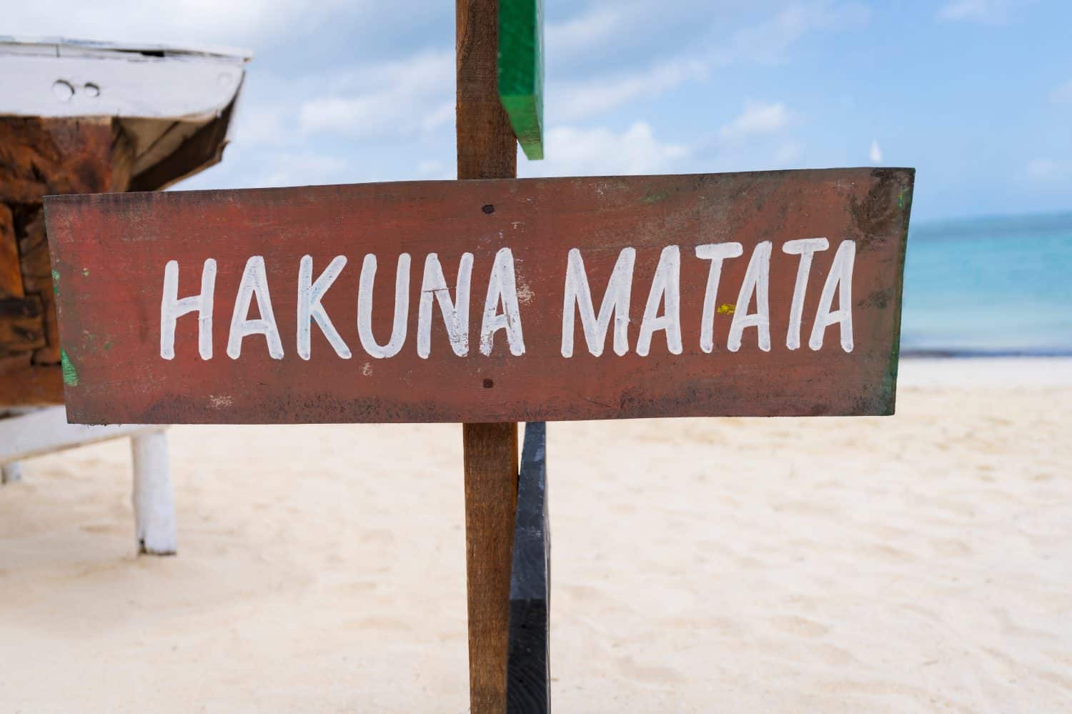 Colorful sign with the writing "Hakuna Matata" on sandy beach at sunny day,relax and summer concept.