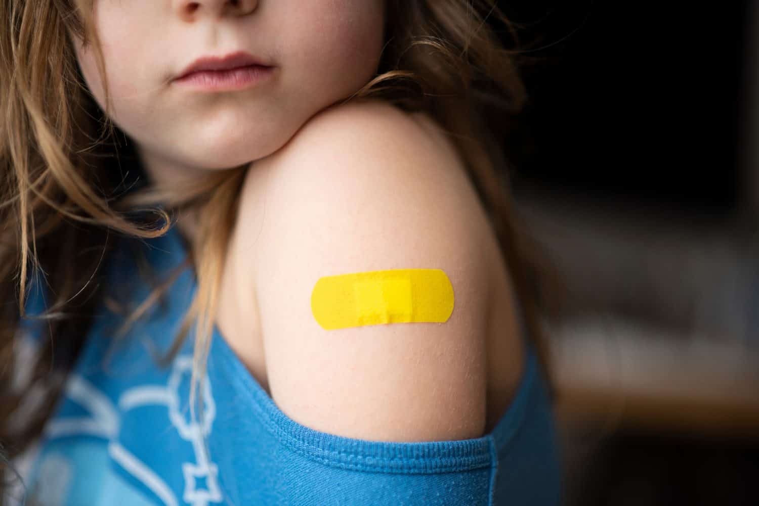 Little girl with a band-aid on her hands, vaccinated against coronavirus infection. Vaccination against COVID-19. Copyspace. High resolution banner. High quality photo