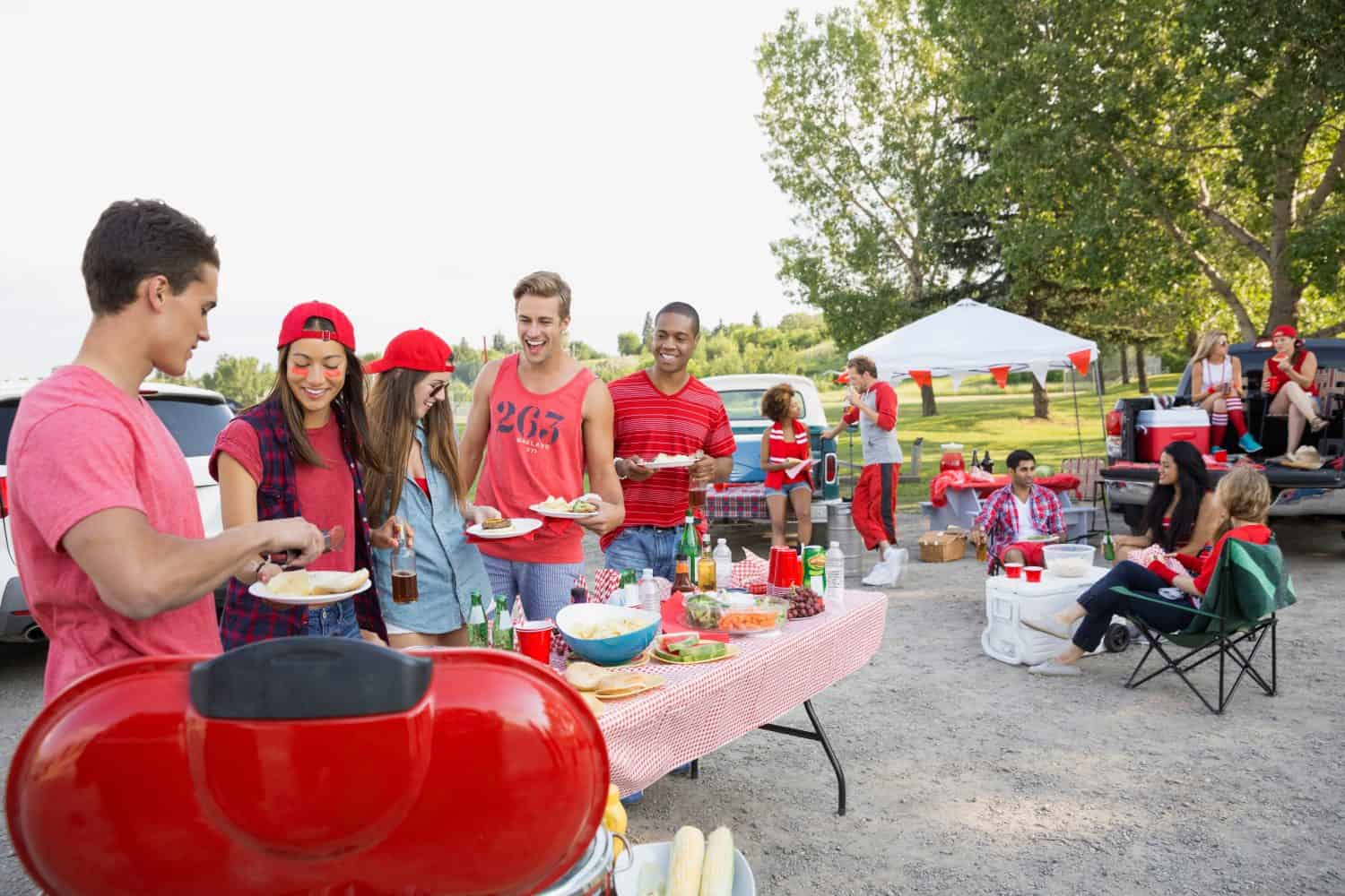 Friends eating at tailgate barbecue in field
