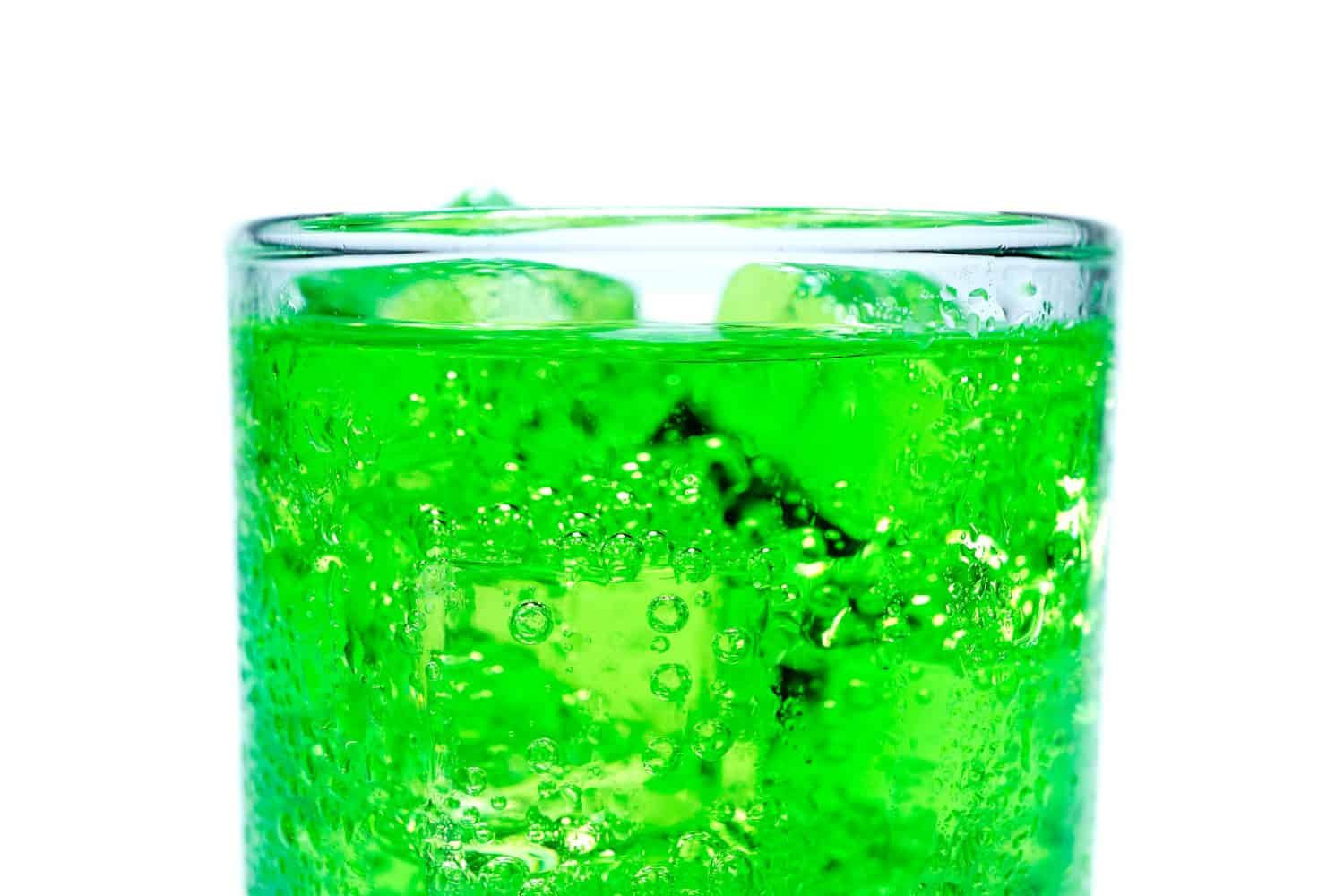 Soft drink, green water in glass and has a white background