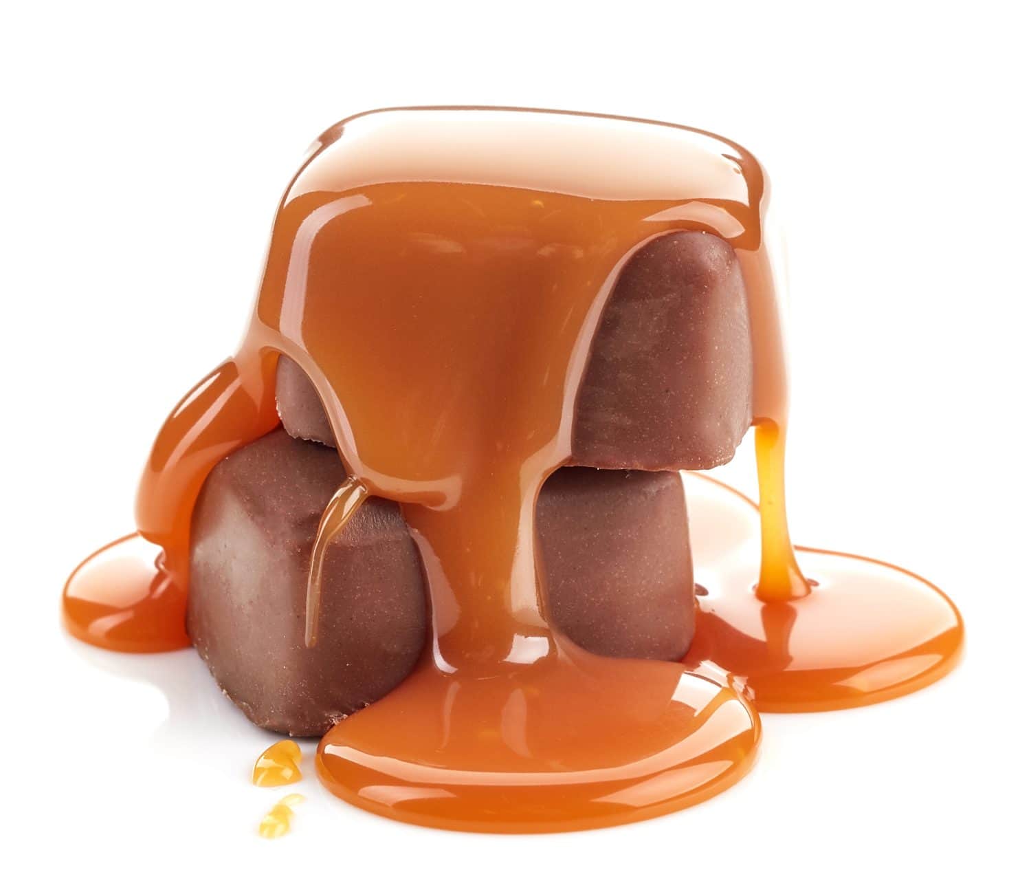 caramel sauce pouring on chocolate candies isolated on white background