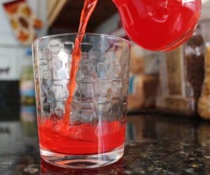 Pouring Red Drink into Glass