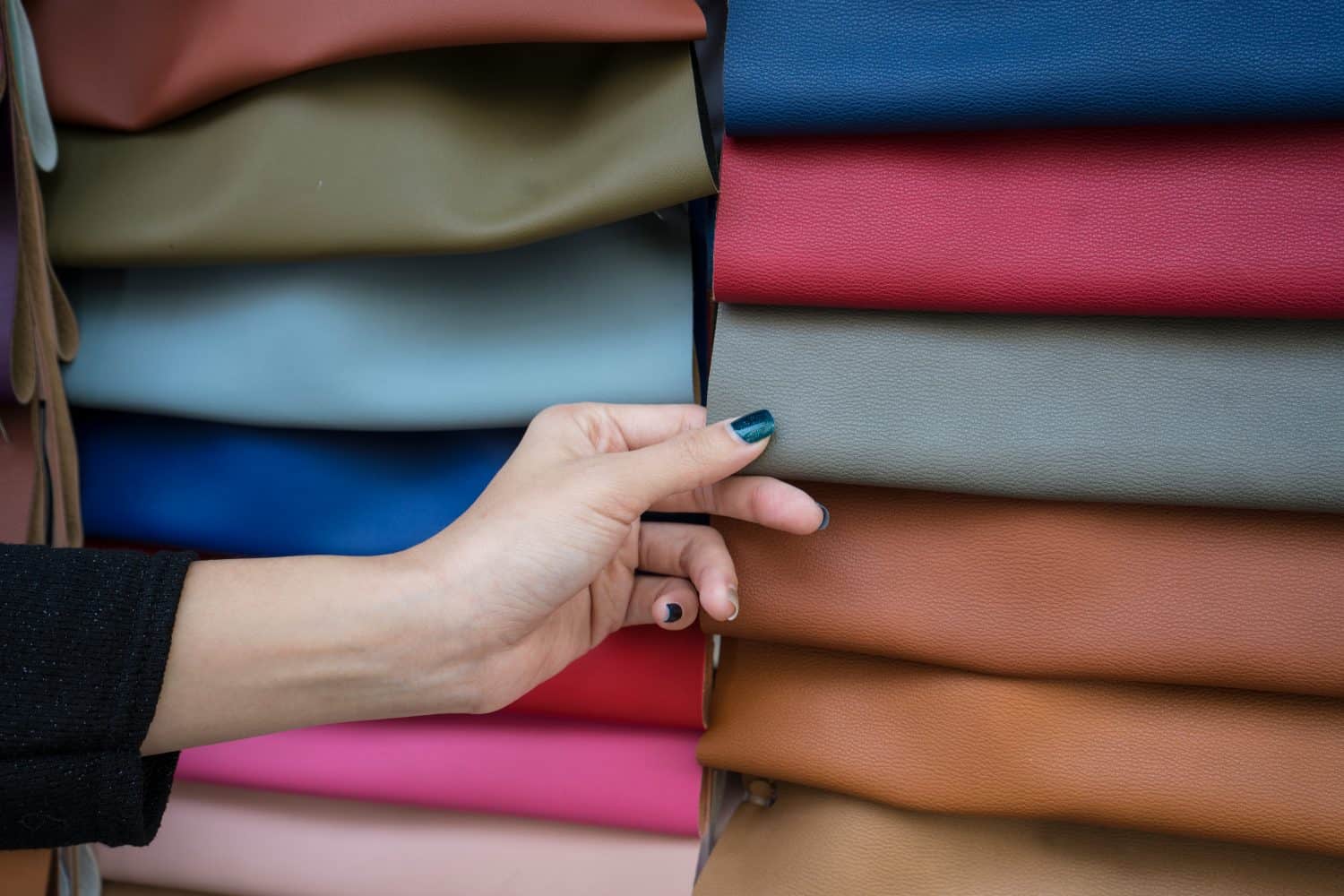 Female hand choosing color of pu leather for her work