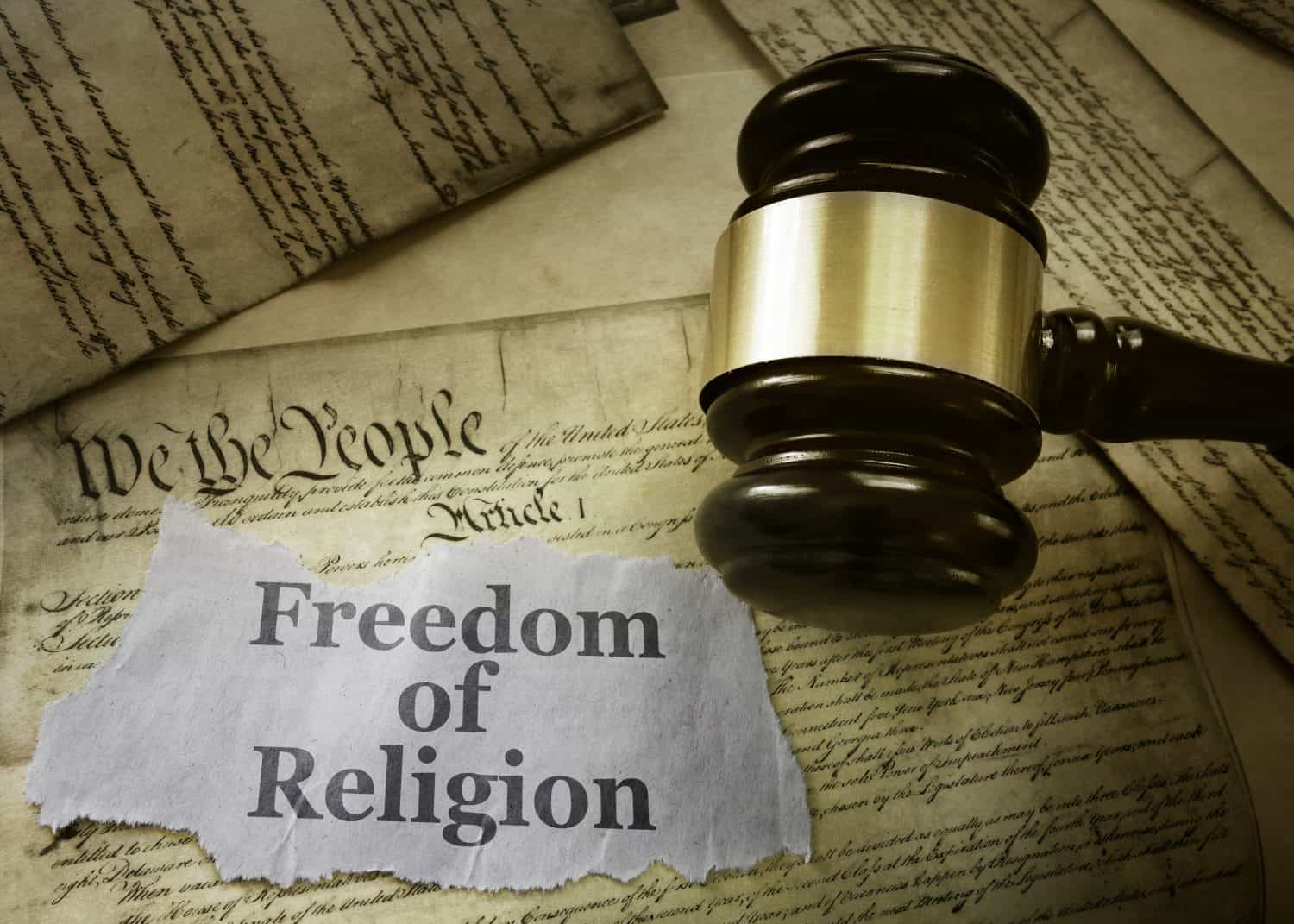 Freedom of Religion newspaper headline on a copy of the US Constitution with gavel