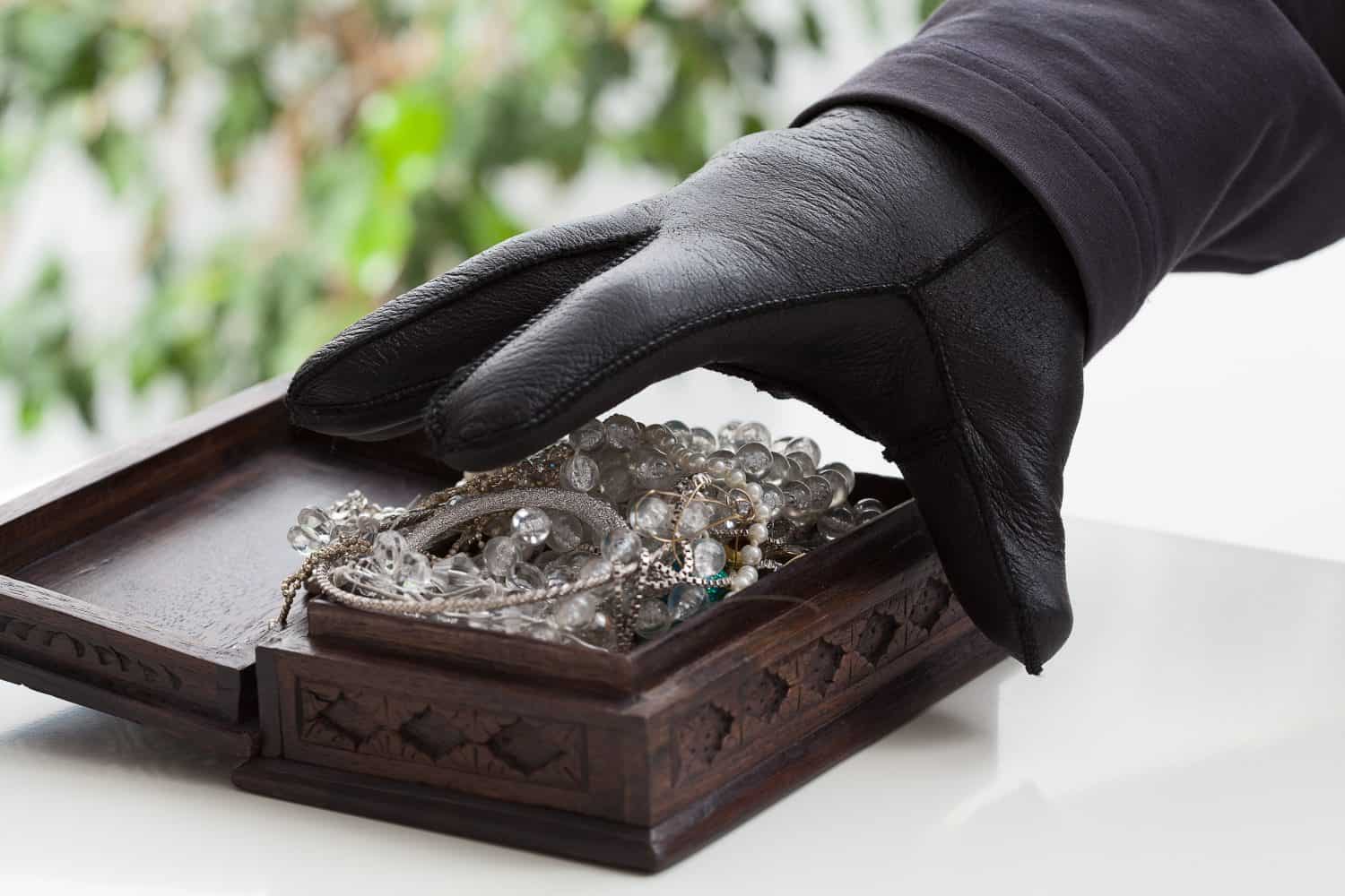 A closeup of a hand of a man about to steal a jewelery box