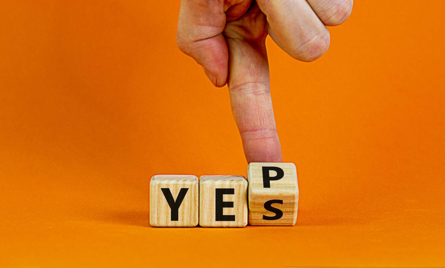 Yes or yep symbol. Businessman turns a cube, changes the word 'yes' to 'yep'. Beautiful orange background. Copy space. Business, motivation and yes or yep concept.