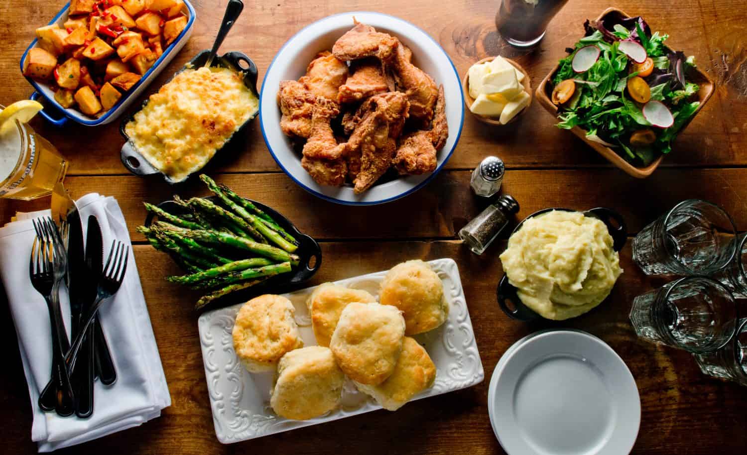 Fried Chicken. Chicken dinner served with potatoes, vegetables and rolls. Chicken, soaked in buttermilk, dredged in flour, spices and fried in a cast iron skillet. Classic American Southern cuisine.