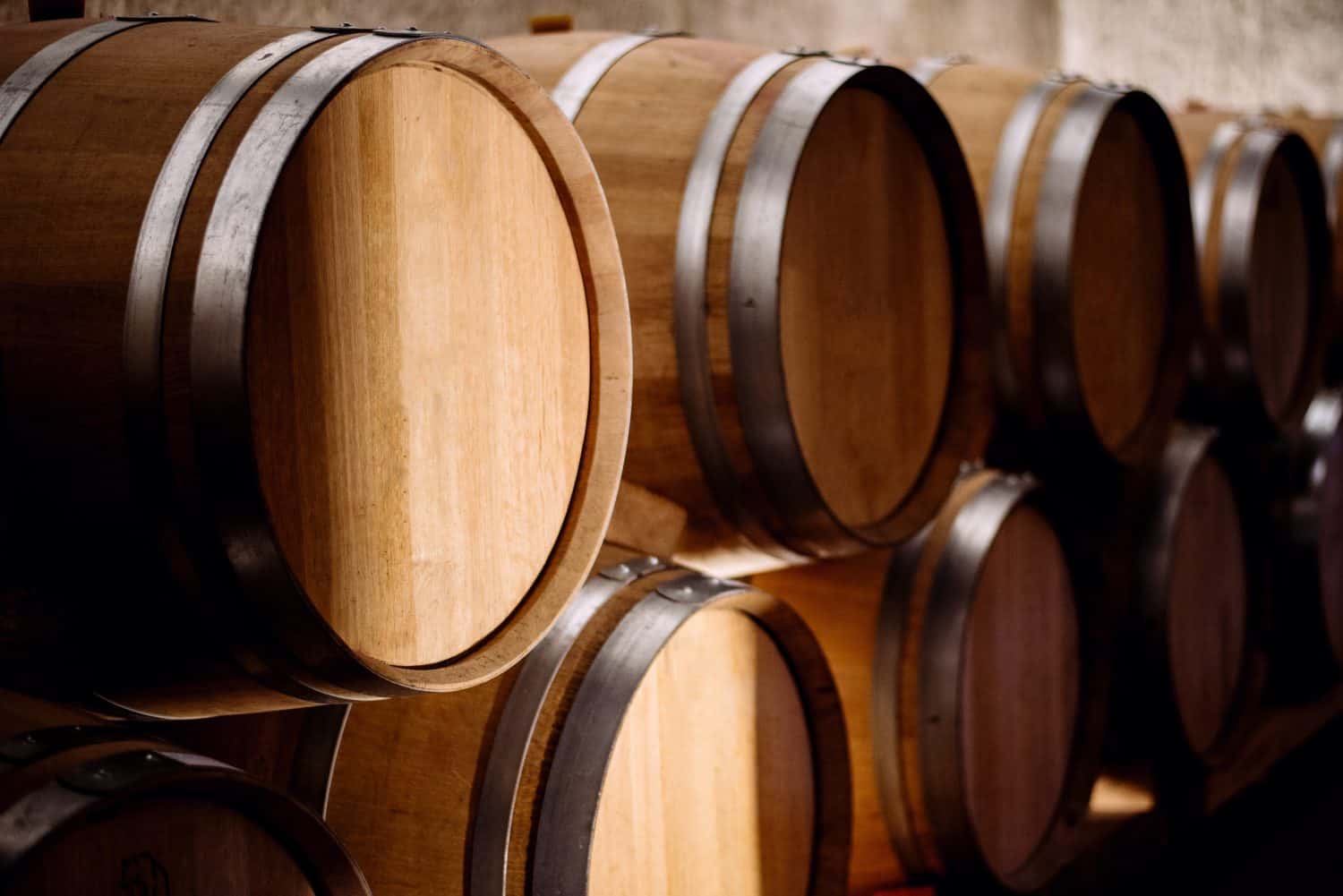 Wooden barrels with silver metal rings, in a wine cellar