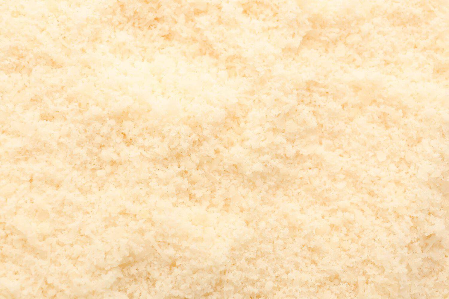 Tasty grated Parmesan cheese as background, closeup