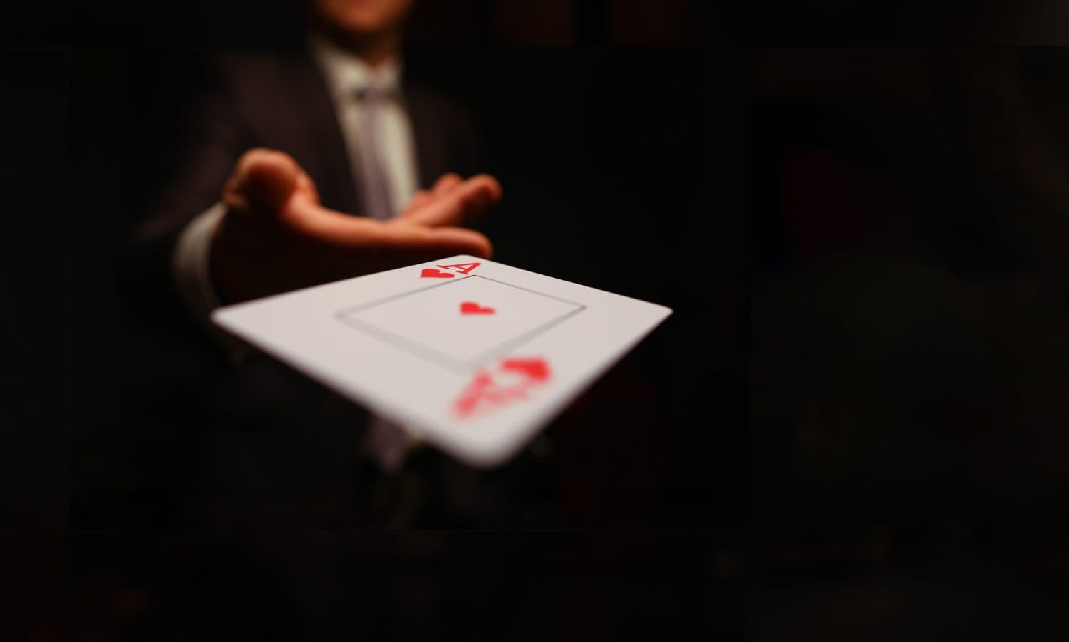 Businessman in suit throws his hand playing card ace of worms to opponent on a black background. Winning in business payout concept