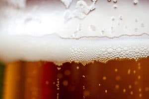 Close shot of the foam of a beer.