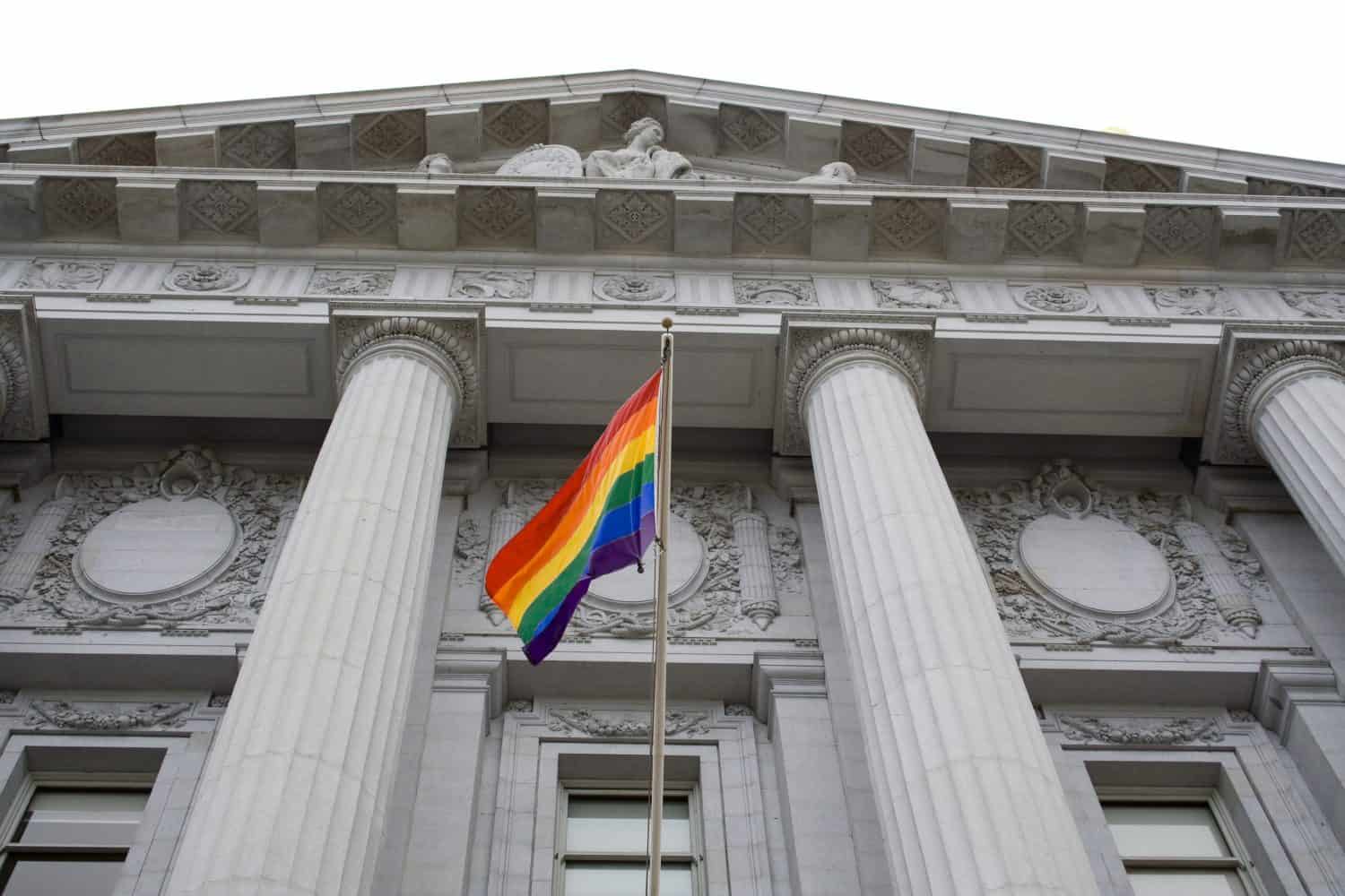 Lesbian, gay, bisexual, and transgender pride flag flying outside a government building