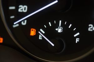 Empty fuel tank indicator close-up on modern car dashboard.