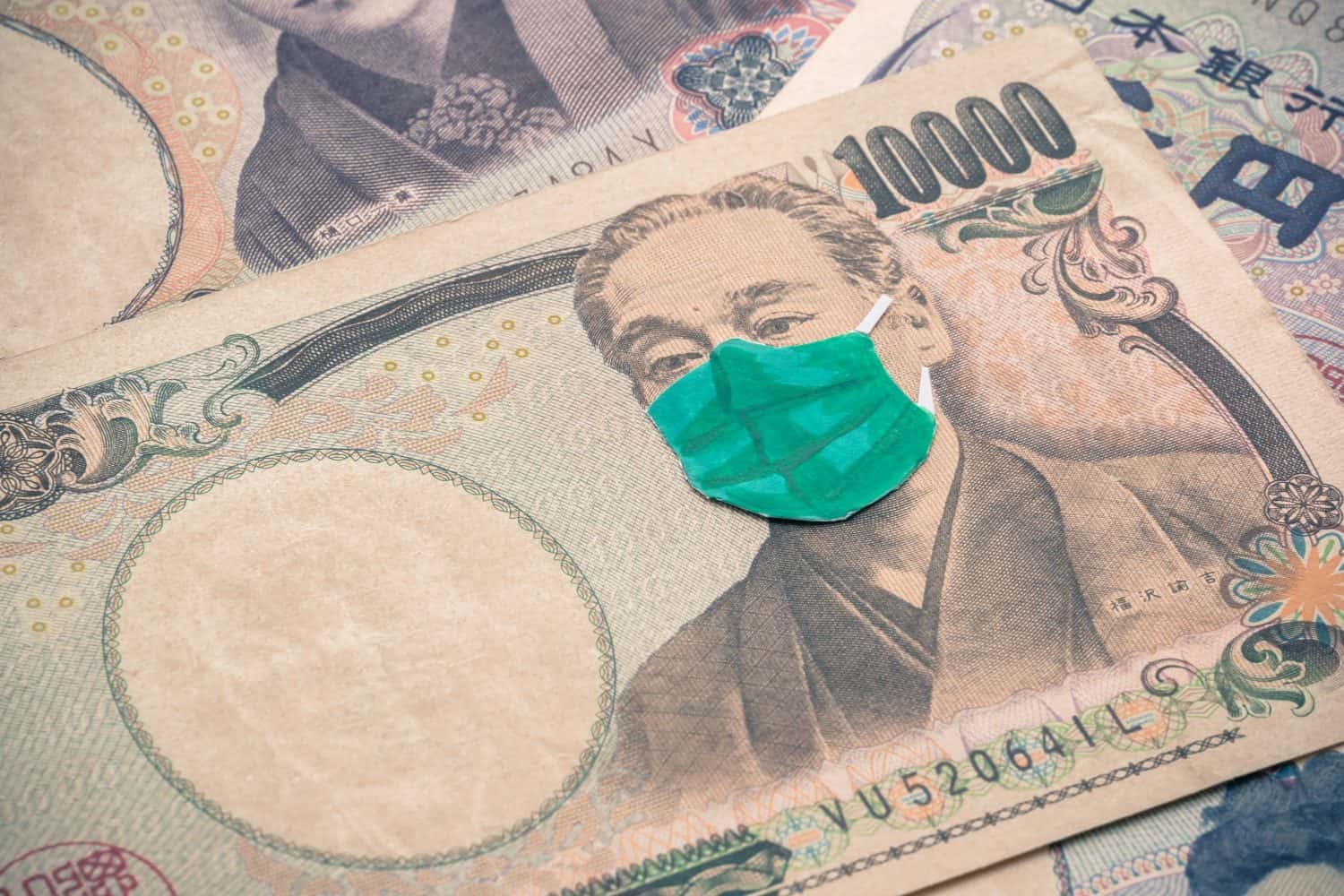 Men wear face mask on Japanese yen bill banknote background. Global novel coronavirus (Covid-19) outbreak effect to Japan, world economy, financial crisis, investment stock market, tokyo olympic 2020
