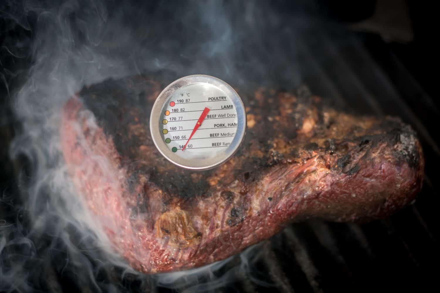 Isolated close up of a delicious beef Picanha meat loaf roasting on a hot grill with a temperature gauge- Israel