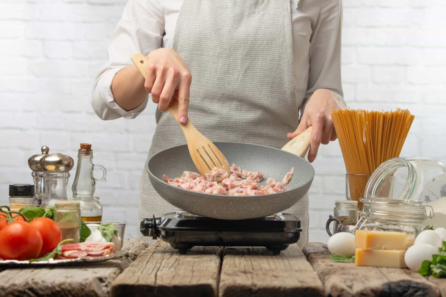 Chef fry bacon for cooking. Culinary recipes, restaurant business, menu