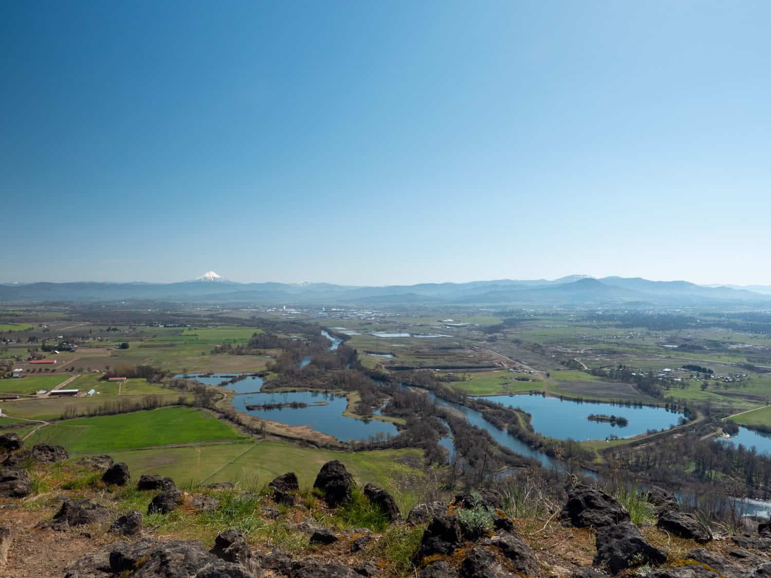 Beautiful landscape with negative space at top. Photo of the Rogue River valley on sunny spring day with the volcano Mt. McLoughlin in the background from Lower Table Rock near Medford, Oregon.