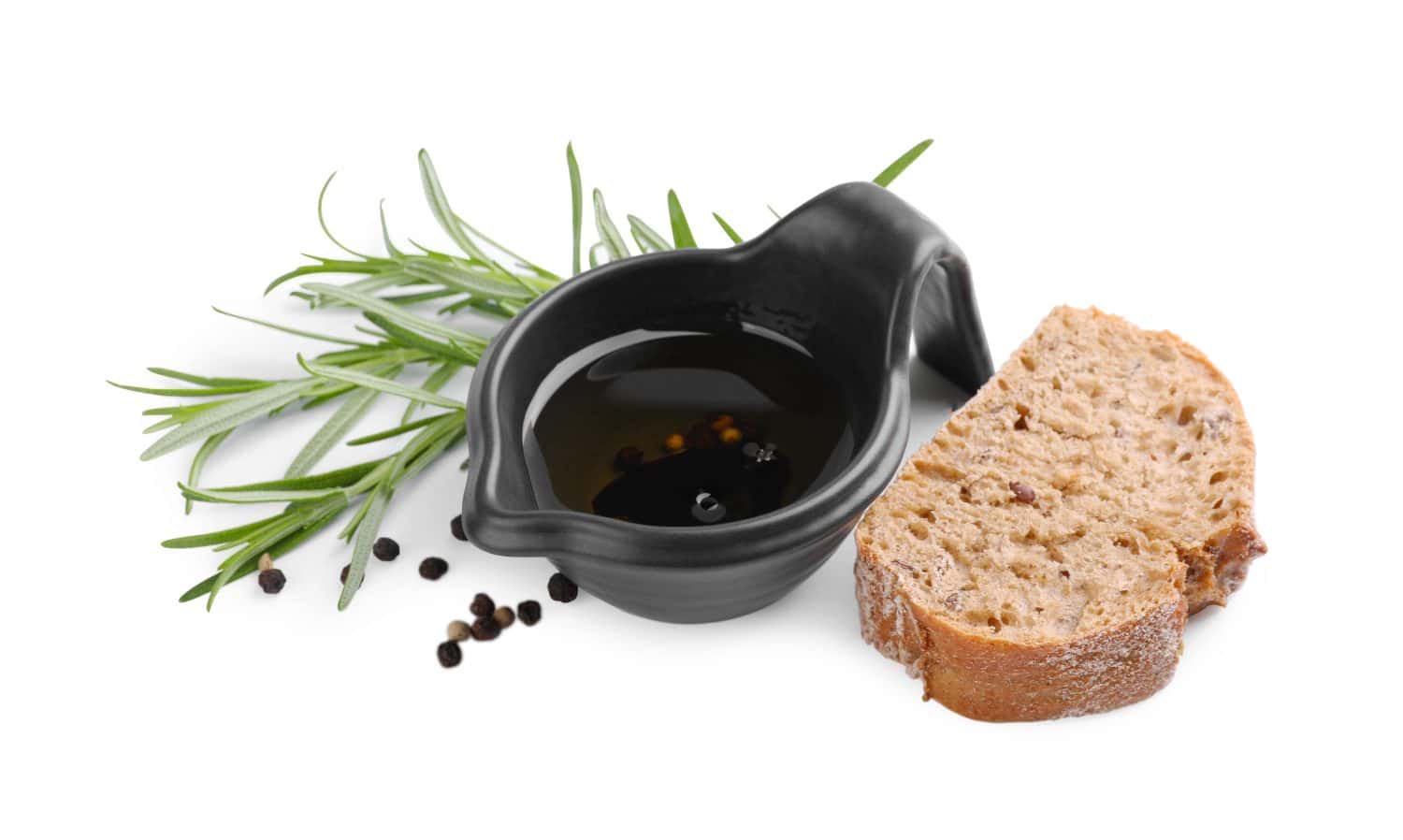 Saucepan of organic balsamic vinegar with oil, spices and bread slices isolated on white
