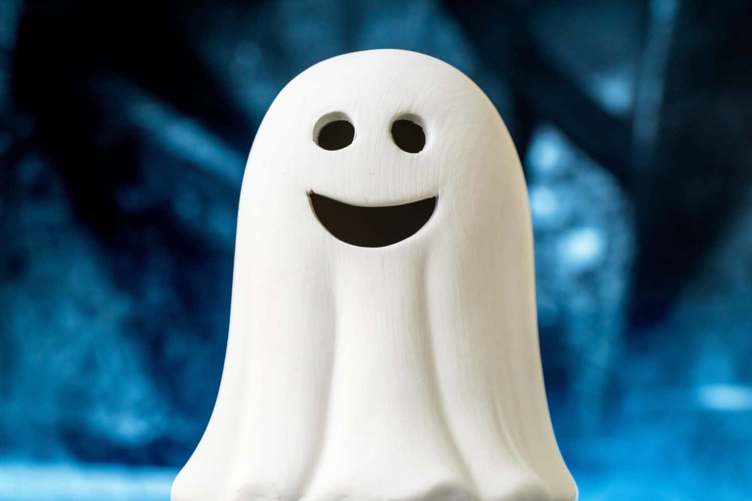 Cute Fun Happy Smiling White Toy Baby Ghost with blue Smokey spooky Halloween Background