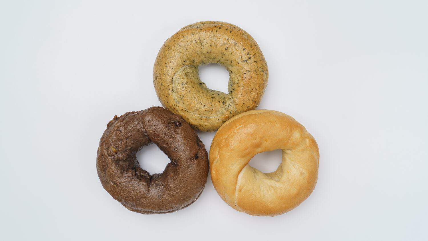 Various types of bagels and coffee.Plain, chocolate and spinach bagels.