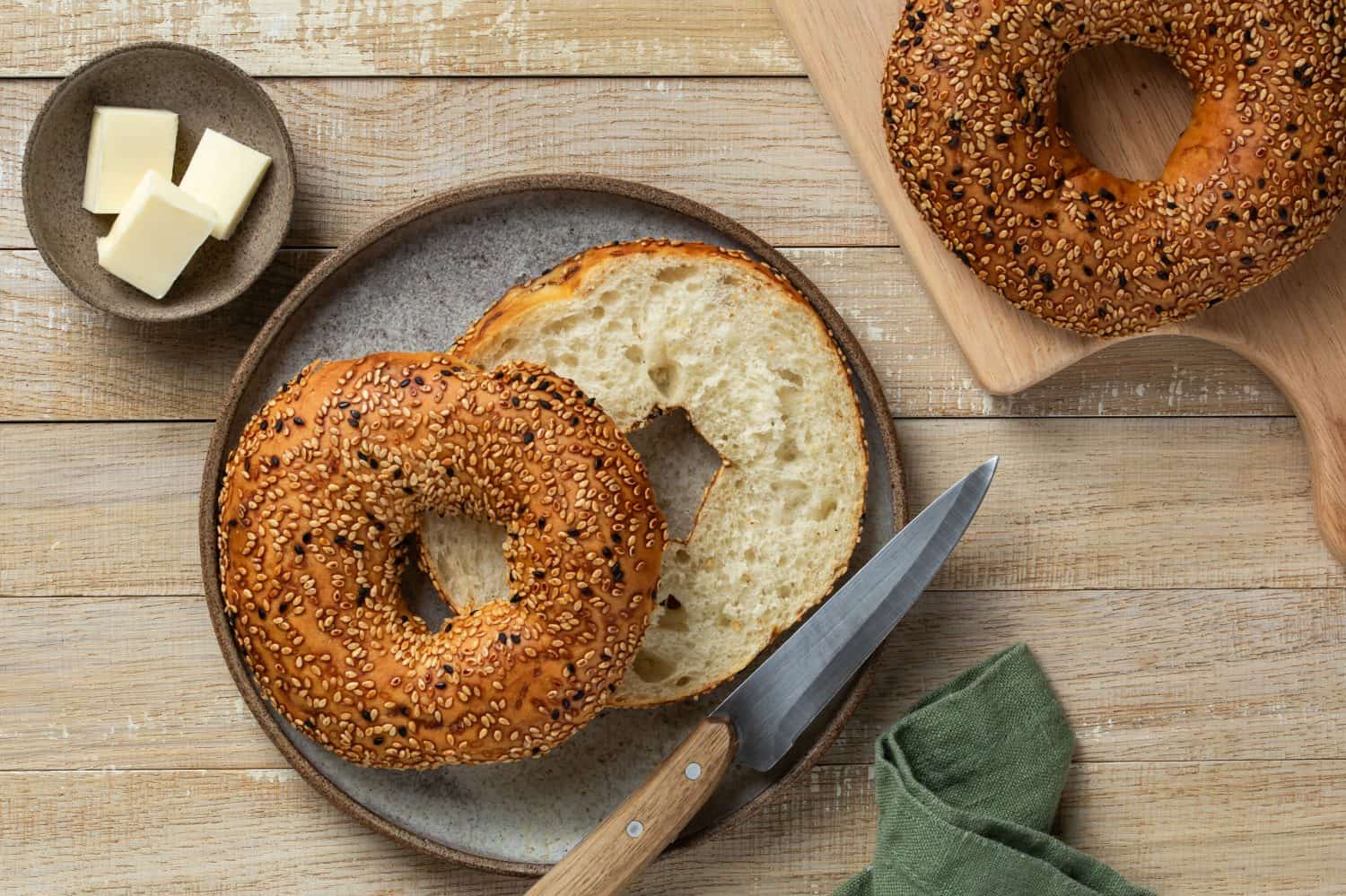 freshly baked bagel, healthy breakfast concept, top view, wooden background, toned