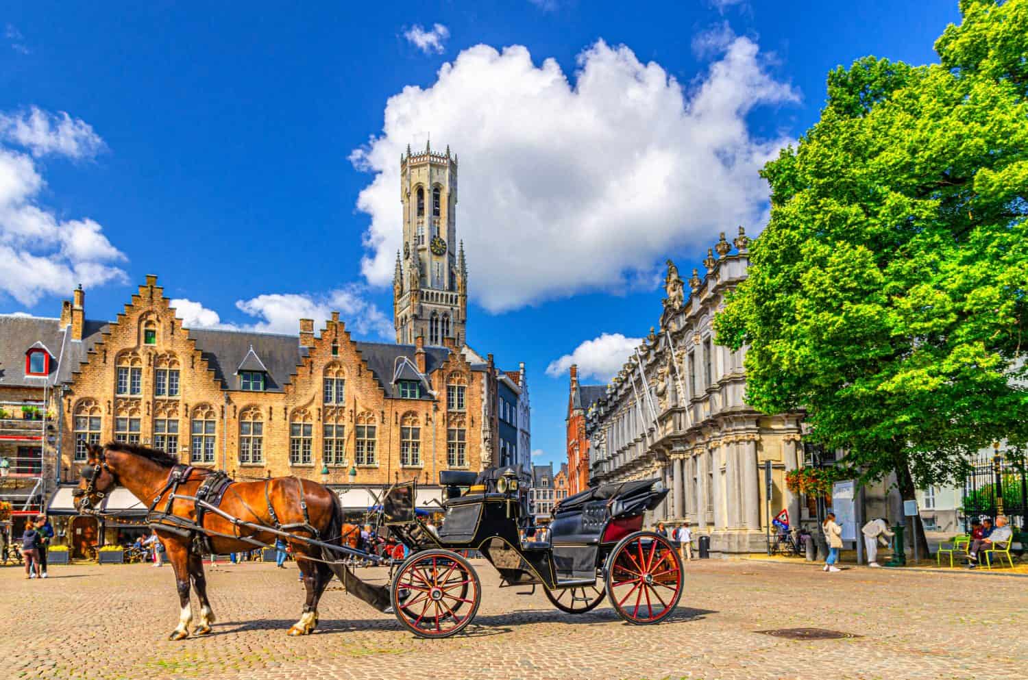 Horse-drawn carriage cart on cobblestone Burg square, medieval buildings and Belfry of Bruges Belfort van Brugge bell tower in Brugge old town, Bruges city historical centre, Flemish Region, Belgium