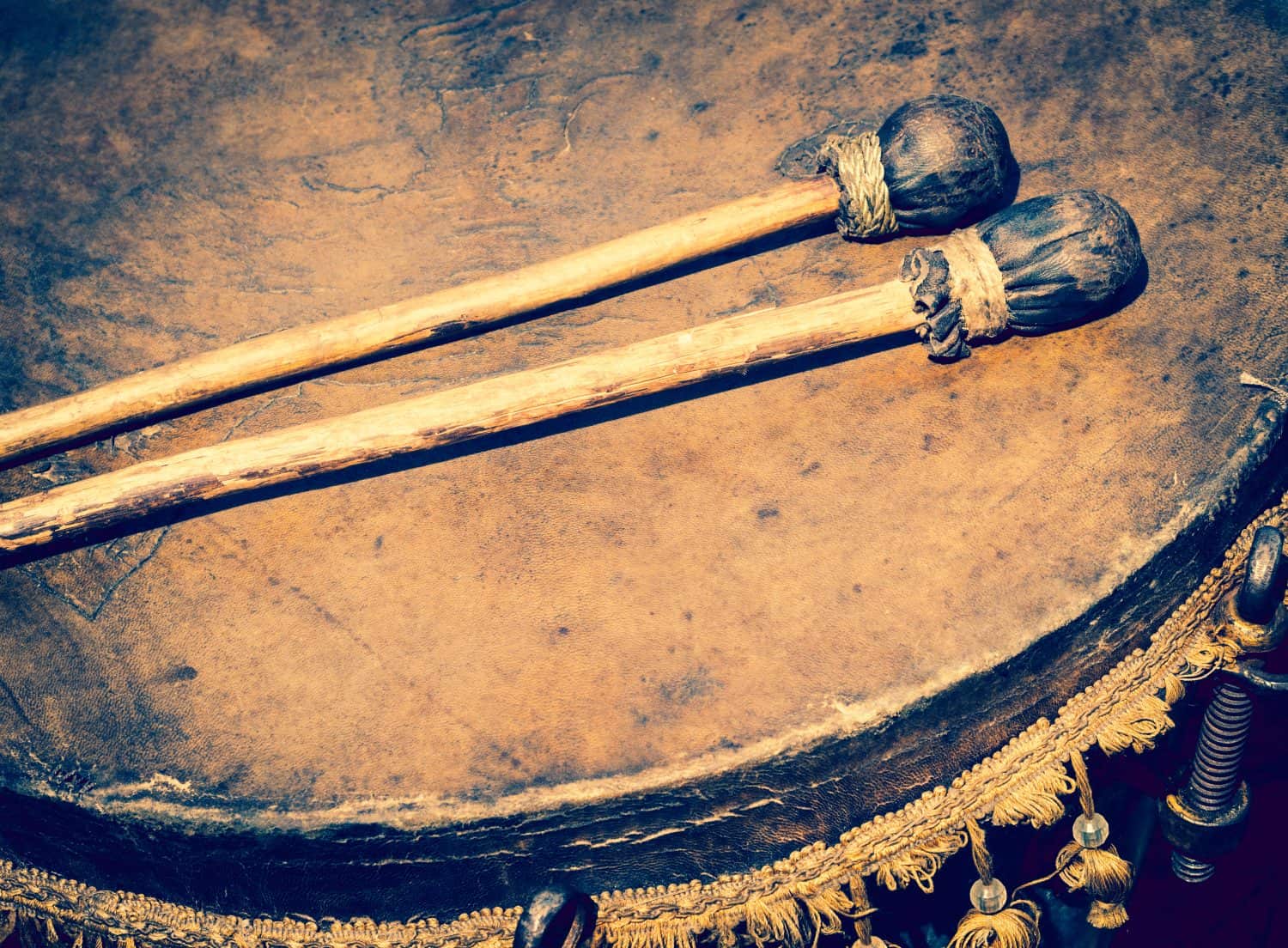 Old leather drum and drumsticks - membrane musical instrument. Ancient ethnic music on a folk festival. Timpani or kettledrums - old musical instruments in percussion family of classical orchestra.