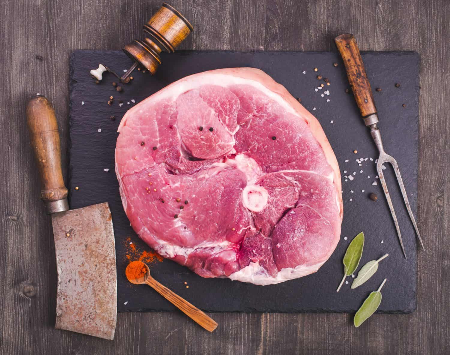 Raw ham cut and kitchen utensils , top view