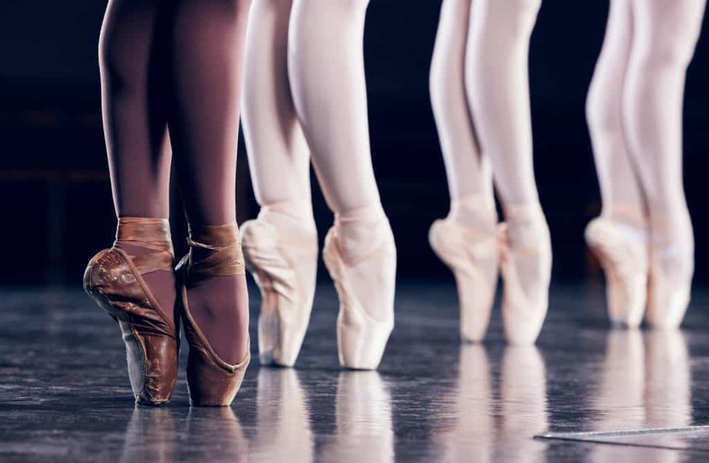 Ballet, shoes and group with dance on stage for performance art, talent and practice of routine. Ballerina, creative performance and people with training for balance, flexibility and elegance