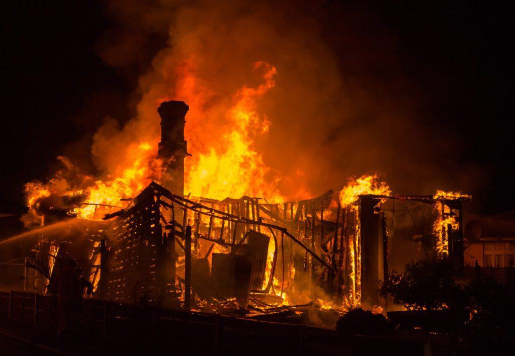 Grand old brick chimney stand tall as it's house burns down around it.
