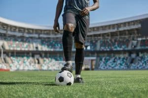 african american man holding a soccer ball in the stadium