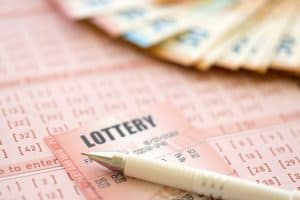 Lottery ticket and gambling receipt on table with pen and European Union euro money bills close up