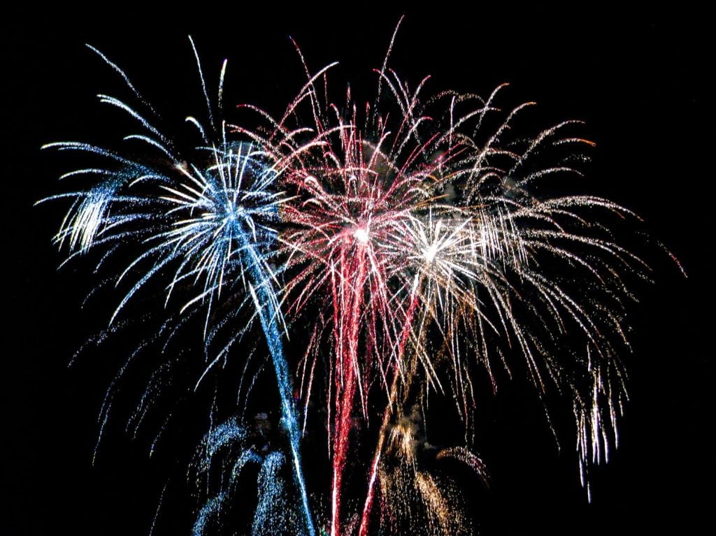 Beautiful colorful holiday fireworks in the evening. Patriotic red, white and blue sparkle. 4th of July. Historical background for celebrations and parties. Independence Day
