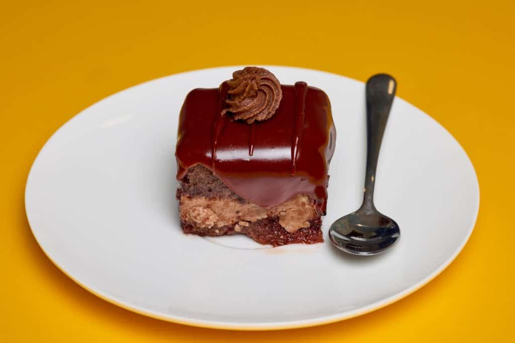 Amandina cake on a plate and a spoon.