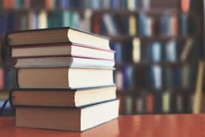 stack of books against the background of library, stack of books in front of library, books on wooden table, education, High quality book photography, Best Book Photo