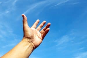 One left hand rise up to bright blue sky and white cloud likey need for something on heaven.
