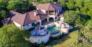 Rich Luxury mansion on large lot of land with Texas hill country landscape and surrounding green surroundings of the ranch country home with infinity pool and wealthy real estate living