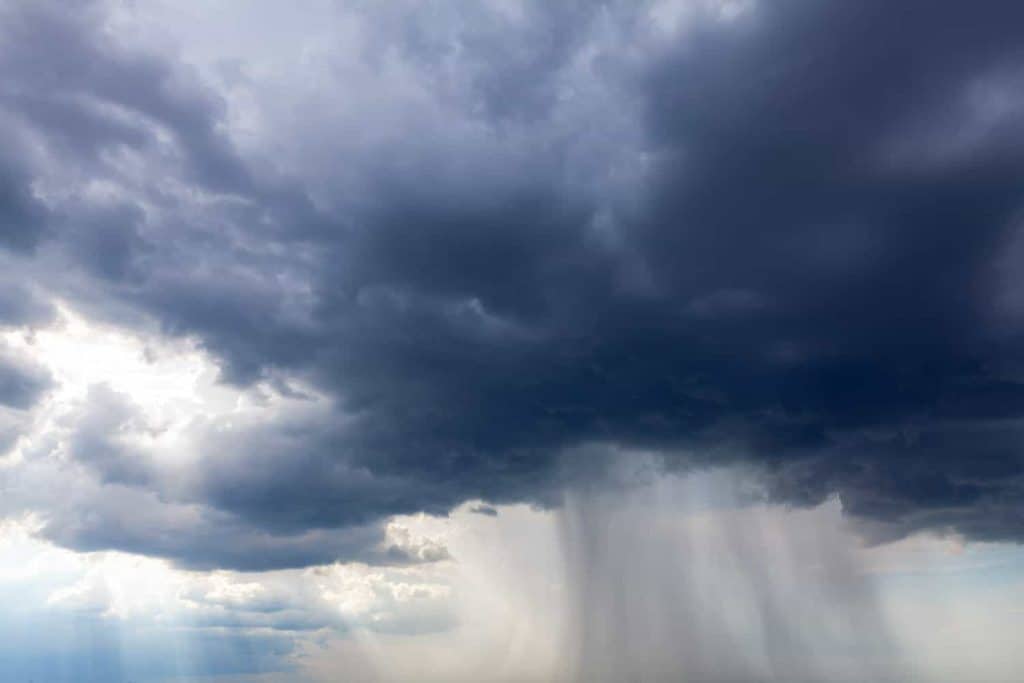 Dark clouds with torrential rain . Heavy rain stream from black clouds