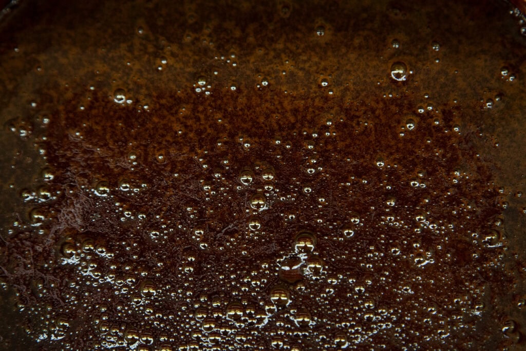  bubbly black molasses in a large vat 