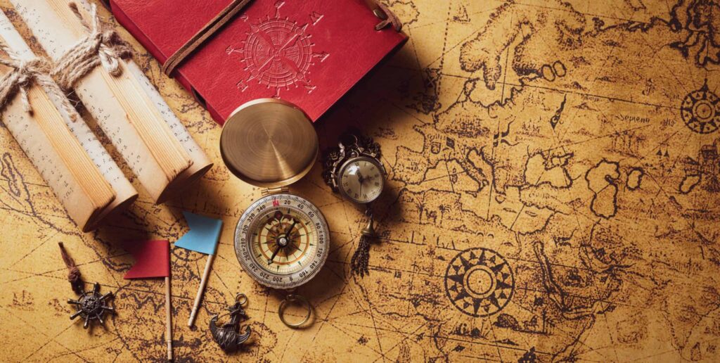 Happy Columbus Day concept. Vintage compass and treasure manuscript. Flat lay, top view with copy space.